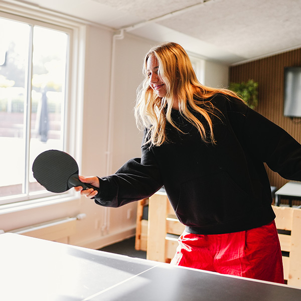 Elev spiller bordtennis i hverdag på SINE med smil på læberne